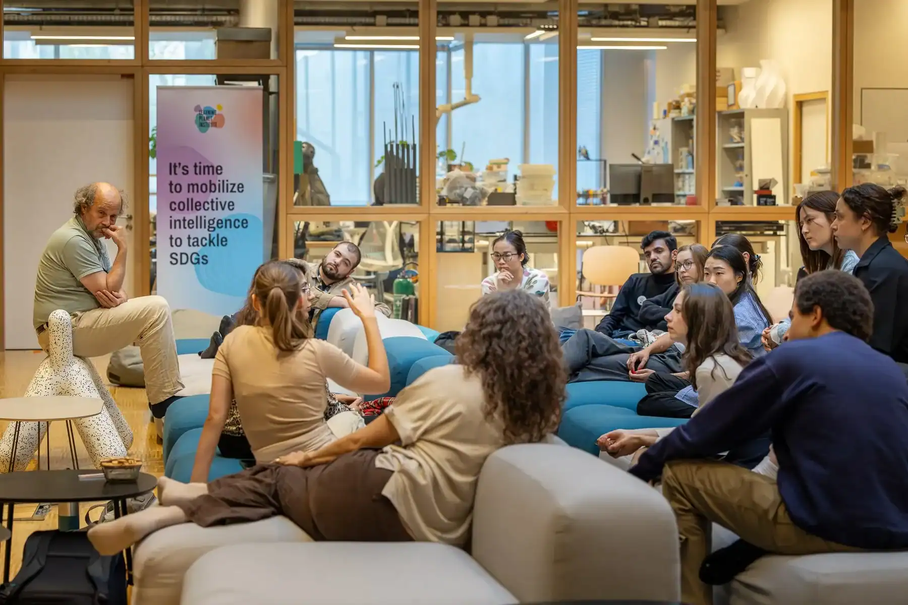 Group discussion in modern collaborative space with participants seated on floor cushions
